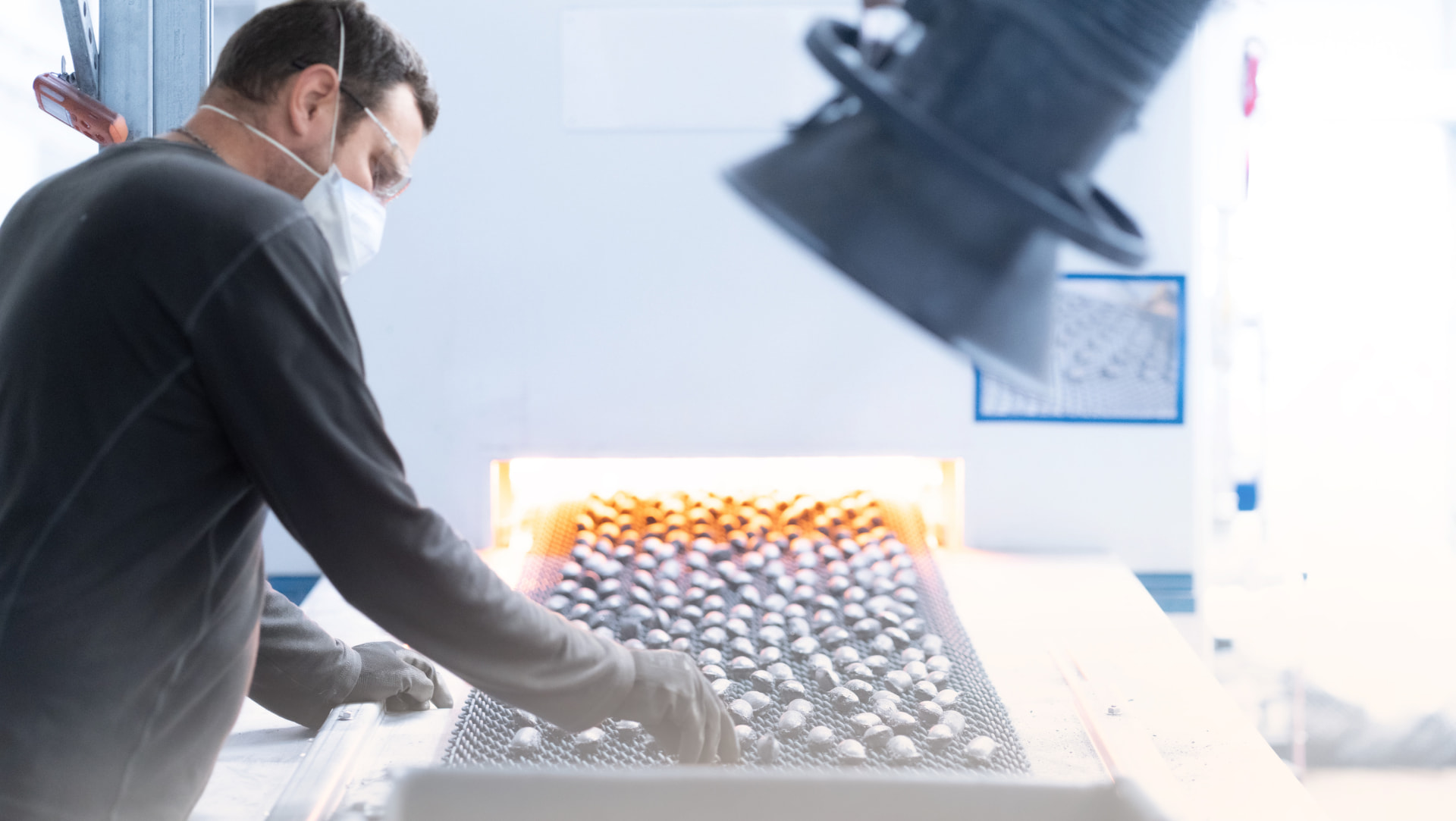 Operator inspecting reduced metallic pellets at the furnace